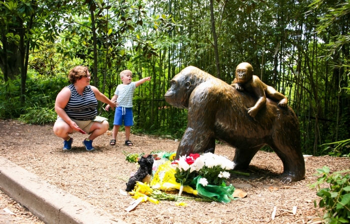 A mother and her child visit a bronze statue of a gorilla outside the Cincinnati Zoo's Gorilla World exhibit, two days after a boy tumbled into its moat and officials were forced to kill Harambe, a Western lowland gorilla, in Cincinnati, Ohio, U.S. May 30, 2016.