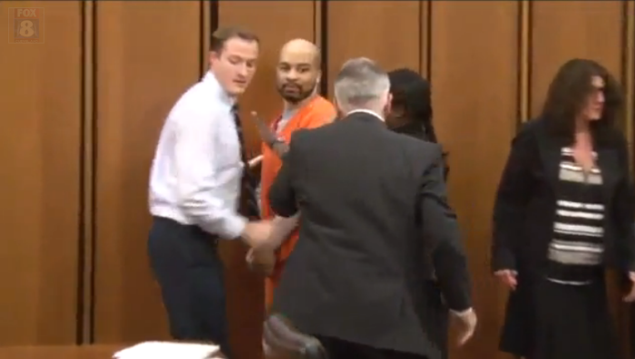 Convicted serial killer Michael Madison (orange suit), 38, is escorted away after an attack from Van Terry.