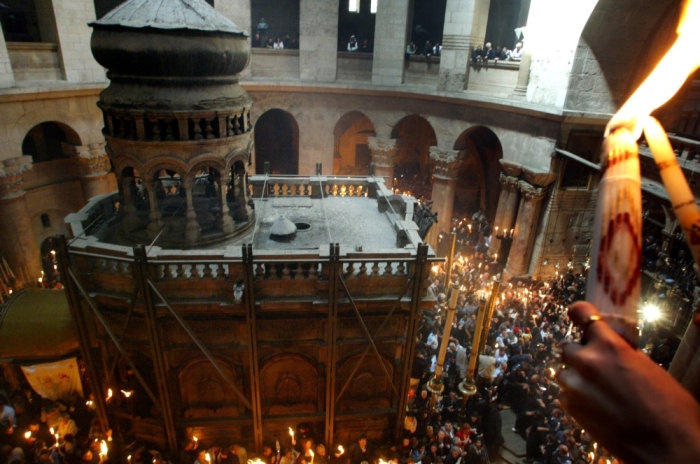 Christian-Orthodox worshipers perform the Holy Fire ceremony on April 26, 2003, inside the Church of the Holy Sepulchre in Jerusalem's Old City which Christian faithful believe is built on the site of Jesus' last resting place after his body was removed from the cross. The fire is first taken from inside the tomb and then rapidly spreads throughout the ancient church as faithful light each other's candles.