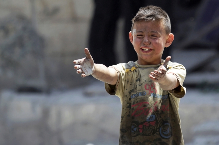 A boy, whose brother was killed, reacts at a site hit by airstrikes in the rebel-controlled area of Maaret al-Numan town in Idlib province, Syria, June 2, 2016.