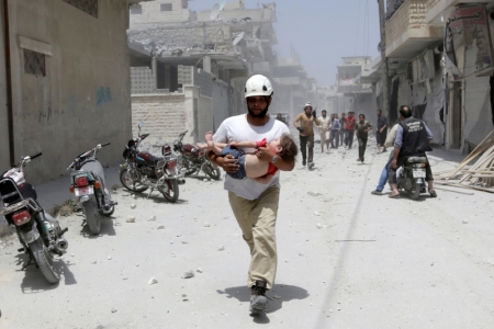 A civil defence member carries an injured girl at a site hit by airstrikes in the rebel-controlled area of Maaret al-Numan town in Idlib province, Syria June 2, 2016.