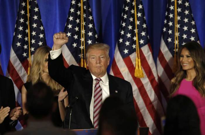 Republican U.S. presidential candidate Donald Trump pumps his fist as his wife Melania (R) looks on at the end of his statement at a campaign event on the day that several states held presidential primary elections, including California, at the Trump National Golf Club Westchester in Briarcliff Manor, New York, U.S., June 7, 2016.