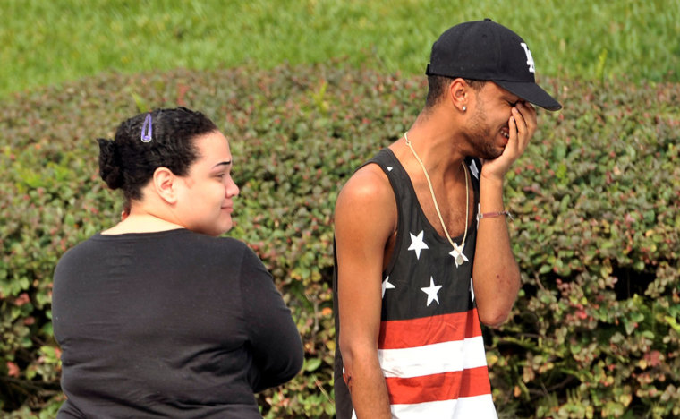 Friends and family members embrace outside the Orlando Police Headquarters during the investigation of a shooting at the Pulse nightclub, where people were killed by a gunman, in Orlando, Florida, U.S June 12, 2016.