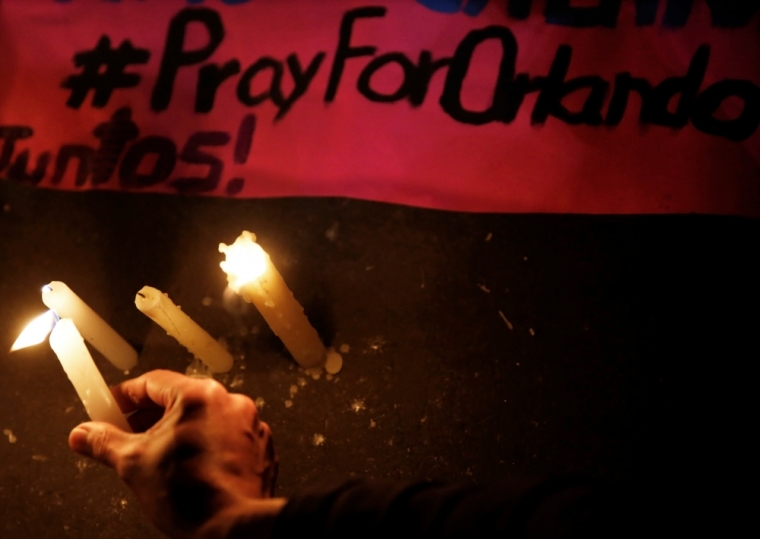 A man places a candle as a sign of condolence for victims of a mass shooting at a gay nightclub in Orlando, Florida, U.S., in Sao Paulo, Brazil, June 12, 2016.