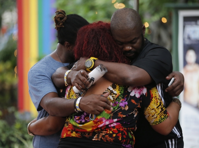 People embrace following a candlelight vigil at the Parliament House Resort after an early morning shooting attack at a gay nightclub in Orlando, Florida, U.S. June 12, 2016.