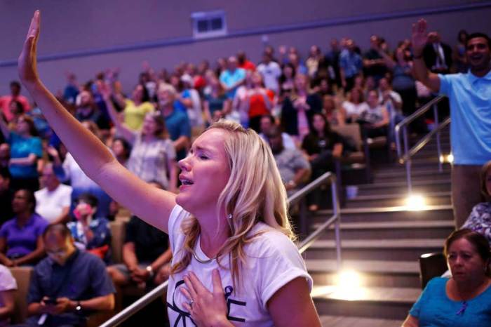 Local resident Diane Clarke Jack raises her hand in prayer during a memorial service at the First Baptist Church Of Orlando for victims of the Pulse gay night club shooting in Orlando, Florida, U.S., June 14, 2016.