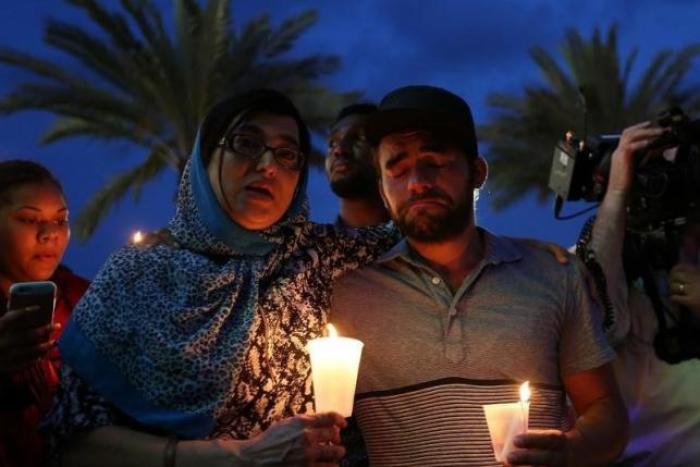 People take part in a candlelight memorial service the day after a mass shooting at the Pulse gay nightclub in Orlando, Florida, U.S. June 13, 2016.