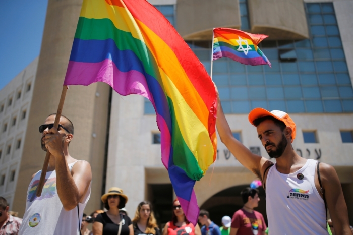 Revellers observe a minute's silence in memory of the victims of the Pulse gay nightclub shooting in Orlando, Florida, during a gay pride parade in the southern city of Ashdod, Israel, June 17, 2016.