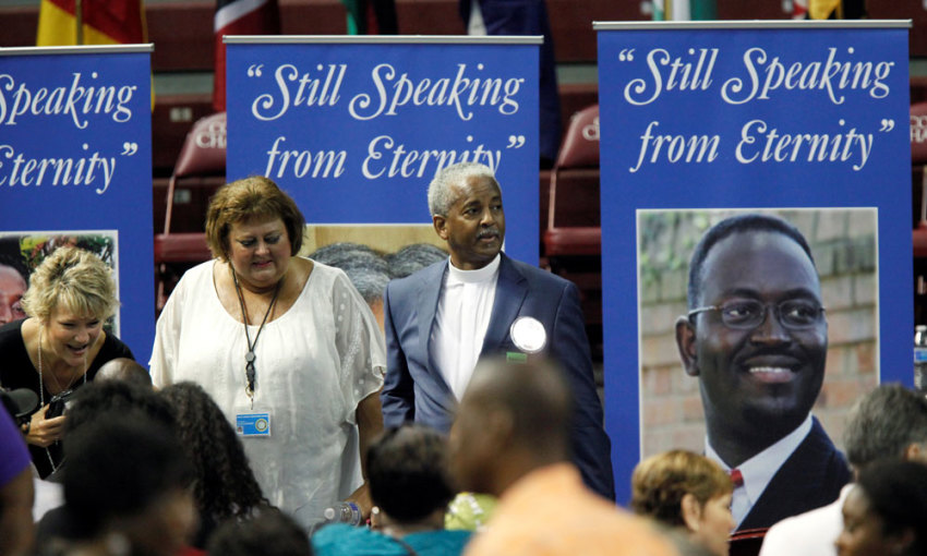 The Rev. Anthony Thompson, husband of victim Myra Thompson stands around photos of victims before a memorial ceremony marking the first anniversary of the shootings at Emanuel AME Church during a prayer service where nine people were killed by a gunman, in Charleston , South Carolina U.S. June 17, 2016.