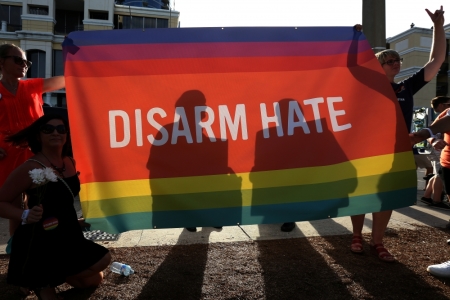 Supporters hold up a "Disarm Hate" sign to block protesters during a vigil for the Pulse night club victims following last weeks shooting in Orlando, Florida, U.S., June 19, 2016.