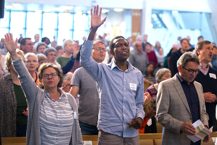 Attendees pray and participate during evangelist Will Graham's recent visit to Norway.