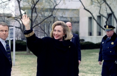 Surrounded by security guards, First Lady Hillary Rodham Clinton waves to reporters outside a heavily guarded Washington courthouse January 26 before testifying before a federal grand jury investigating possible criminal wrongdoing in the Whitewater affair.