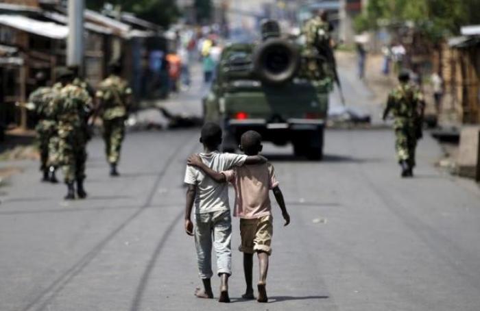 Boys walk behind patrolling soldiers in Bujumbura, Burundi, May 15, 2015