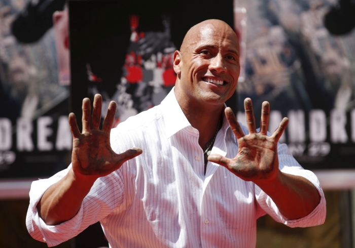 Actor Dwayne 'The Rock' Johnson poses after putting his hands in cement during his hand and footprints ceremony in the forecourt of the TCL Chinese Theatre in celebration of his new movie 'San Andreas,' in Hollywood, California, May 19, 2015.