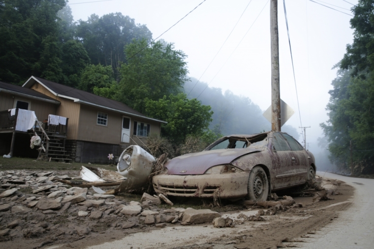 A destroyed car rests in front of a house after flooding in Clendenin, West Virginia, June 26, 2016.