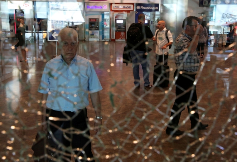 A man looks at a broken glass at Istanbul Ataturk airport, Turkey, following yesterday's blast June 29, 2016.