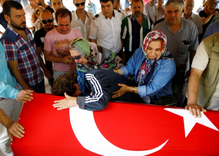 Relatives of Gulsen Bahadir, a victim of Tuesday's attack on Ataturk airport, mourn at her flag-draped coffin during her funeral ceremony in Istanbul, Turkey, June 29, 2016.