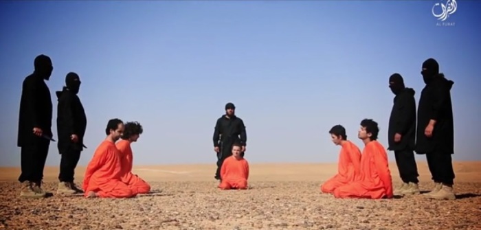 Islamic State militants stand behind accused spies in a publicized beheading video that was filmed in the Syrian desert and posted to pro-IS media outlets on June 28, 2016.