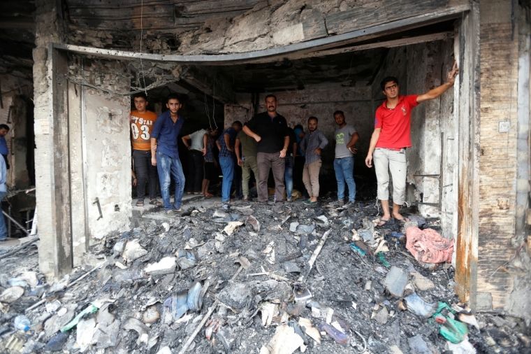 People inspect the site after a suicide car bomb attack at the shopping area of Karrada, a largely Shi'ite district, in Baghdad, Iraq July 4, 2016.