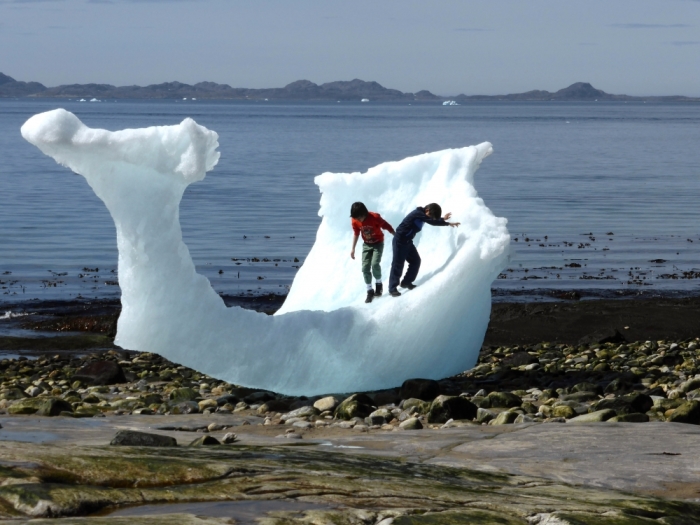 Children play amid icebergs on the beach in Nuuk, Greenland.