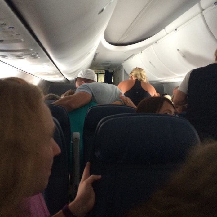 Tim Tebow prays with fellow-passengers as a man suffers a fatal heart attack on Delta Flight, June 2016.