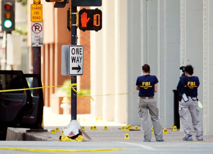 FBI investigators look over the crime scene in Dallas, Texas, July 8, 2016, following a Thursday night shooting incident that killed five police officers.