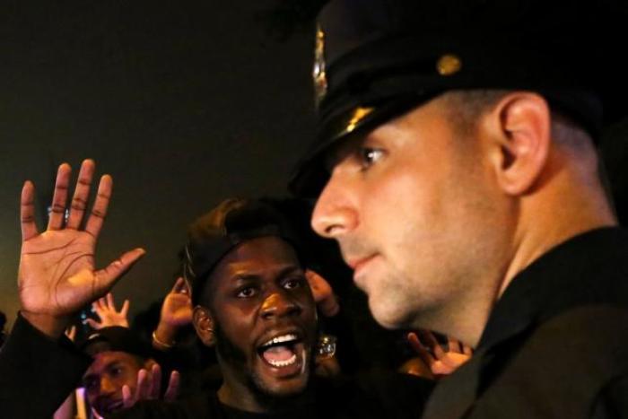 A protester shouts 'Look at me' towards a NYPD police officer during a march against police brutality in Manhattan, New York, U.S., July 9, 2016.