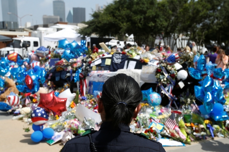 A Dallas police officer is pictured at a makeshift memorial at police headquarters following the multiple police shootings in Dallas, Texas, July 11, 2016.