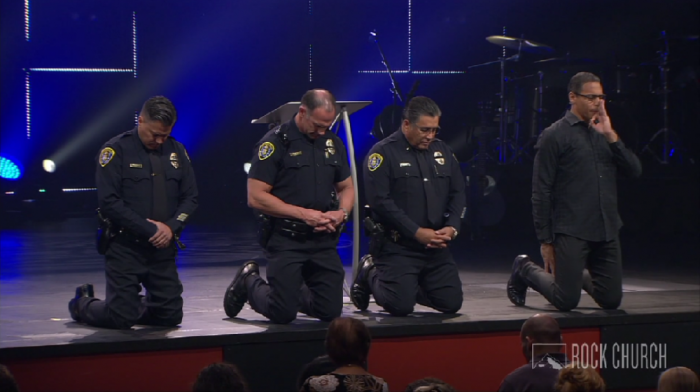 Miles McPherson, pastor of The Rock Church of San Diego, California, prays with three police officers at a worship service on Sunday, July 10, 2016.