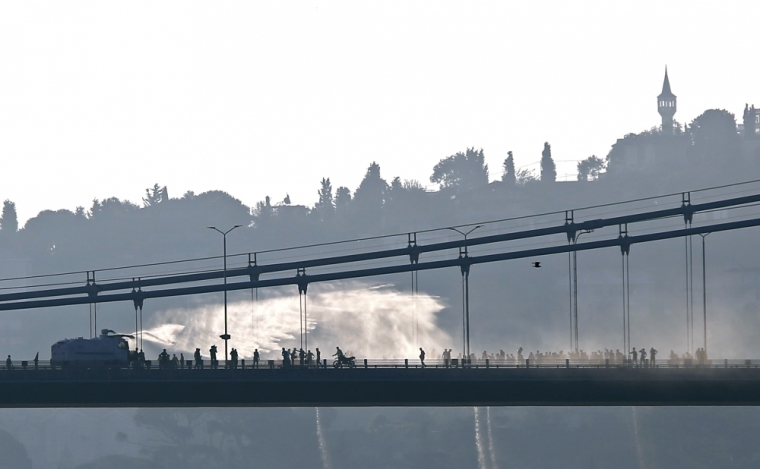 A police armored vehicle uses a water cannon to disperse anti-goverment forces on Bosphorus Bridge in Istanbul, Turkey, July 16, 2016.