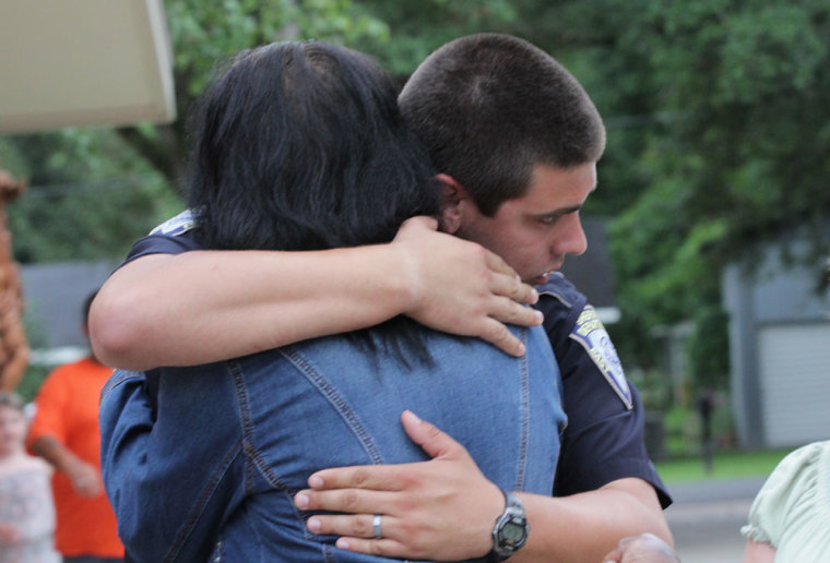 A police officer is embraced after a vigil for the fatal attack on Baton Rouge policemen, at Saint John the Baptist Church in Zachary, Louisiana, July 17, 2016