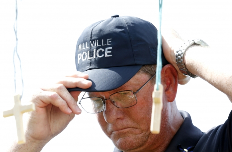 Bob Ossler, a chaplain for the Police and Fire Department of Millville, New Jersey, visits a makeshift memorial for three police officers who were shot and killed in Baton Rouge, Louisiana, July 18, 2016.