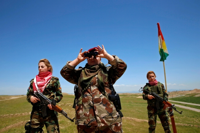 Iraqi Kurdish female fighter Haseba Nauzad looks through a pair of binoculars during a deployment near the frontline of the fight against Islamic State militants in Nawaran near Mosul, Iraq, April 20, 2016.
