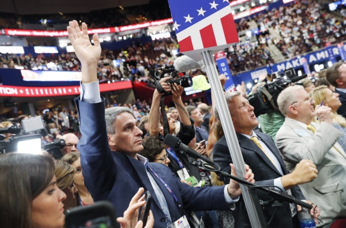 Former Virginia Attorney General Ken Cuccinelli (L), a leader in a movement to not accept the Republican National Convention Rules Committee's report and rules changes, tries to get the attention of the podium to be recognized as the convention descended into chaos over the controversy at the Republican National Convention in Cleveland, Ohio, U.S. July 18, 2016.