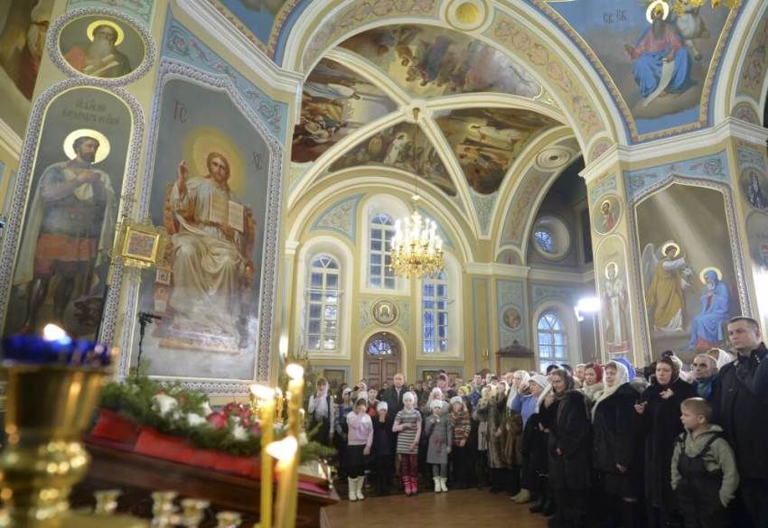Russian President Vladimir Putin (5th L) and believers attend the Orthodox Christmas service at a local church in the settlement of Turginovo in Tver region, Russia, January 7, 2016. Most Orthodox Christians celebrate Christmas according to the Julian calendar on January 7, two weeks after most western Christian churches that abide by the Gregorian calendar.
