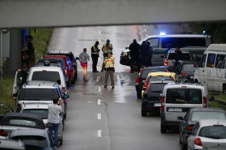 Police halt traffic on a road near to the scene of a shooting rampage at the Olympia shopping mall in Munich, Germany, July 22, 2016.