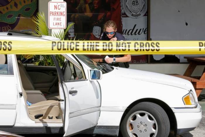 A Fort Myers police officers examines a vehicle in the parking lot of Club Blu after a shooting in Fort Myers, Florida, July 25, 2016.