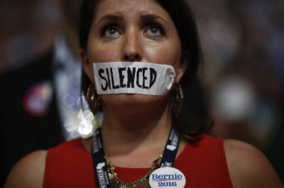 A supporter of former Democratic U.S. presidential candidate Bernie Sanders wears tape across her mouth in protest on the floor at the Democratic National Convention in Philadelphia, Pennsylvania, U.S. July 25, 2016.