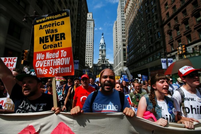 City Hall is seen in the background as supporters of U.S. Senator Bernie Sanders take part in a protest march ahead of the 2016 Democratic National Convention in Philadelphia, Pennsylvania, July 24, 2016.