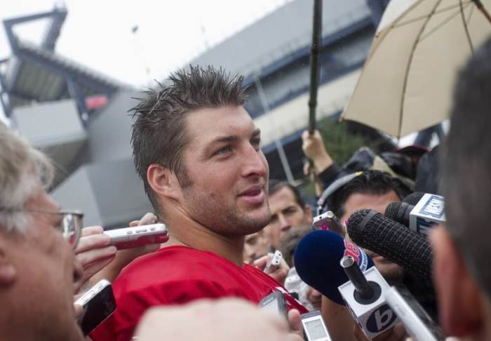 Quarterback Tim Tebow talks to the media as the New England Patriots open their training camp in Foxboro, Massachusetts, July 26, 2013.