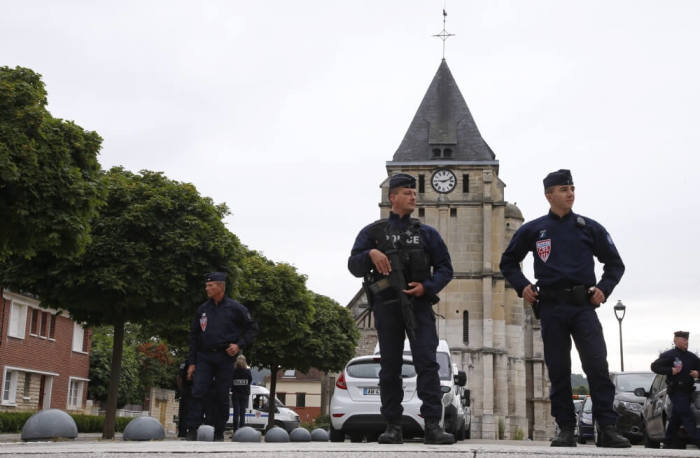 French CRS police stand guard in front of the church a day after a hostage-taking in Saint-Etienne-du-Rouvray near Rouen in Normandy, France, where French priest, Father Jacques Hamel, was killed with a knife and another hostage seriously wounded in an attack on the church that was carried out by assailants linked to Islamic State, July 27, 2016.