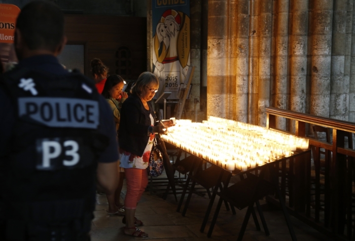 A French policeman stands guard as people attend a mass to pay tribute to French priest Father Jacques Hamel at the Cathedral in Rouen in Normandy, France, July 27, 2016. Father Jacques Hamel was killed on Tuesday in an attack on a church at Saint-Etienne-du-Rouvray near Rouen that was carried out by assailants linked to Islamic State.