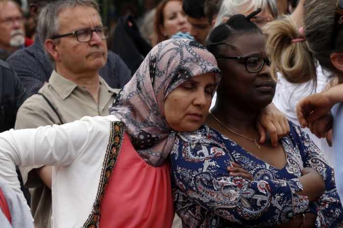 People attend a tribute July 28, 2016 to French priest, Father Jacques Hamel, killed on Tuesday in an attack on the church in Saint-Etienne-du-Rouvray, near Rouen, France, that was carried out by assailants linked to Islamic State.