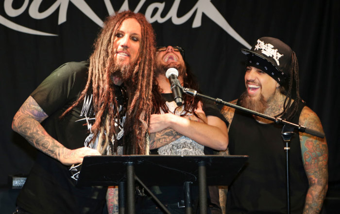 Members of the hard rock group KORN speak prior to a handprint ceremony honoring the group at Hollywood's RockWalk at the Guitar Center in Los Angeles October 8, 2013. Seen (L-R) are Brian Welch, Jonathan Davis and Reggie Arvizu.