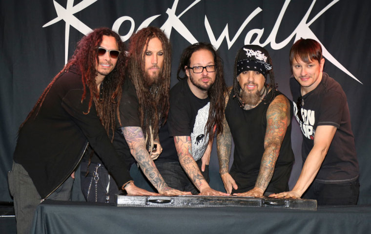 Members of the hard rock group KORN cast their handprints in cement during a ceremony honoring the group at Hollywood's RockWalk at the Guitar Center in Los Angeles October 8, 2013. Seen (L-R) are James Shaffer, Brian Welch, Jonathan Davis, Reggie Arvizu and Ray Luzier.
