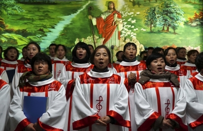 Credit : Choristers sing Christmas carols in front of a figure of Jesus Christ, during a mass at a catholic church in Shenyang, Liaoning province, China, December 24, 2014.