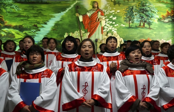 Choristers sing Christmas carols in front of a figure of Jesus Christ, during a mass at a catholic church in Shenyang, Liaoning province, China, December 24, 2014.