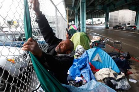 Credit : Jonathan Payne, a homeless man, takes down tarps he had used to protect his possessions during an El Nino driven storm in San Francisco, California, January 6, 2016.