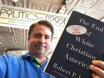 Robert P. Jones, founding CEO of the Public Religion Research Institute poses with his new book, “The End of White Christian America.”