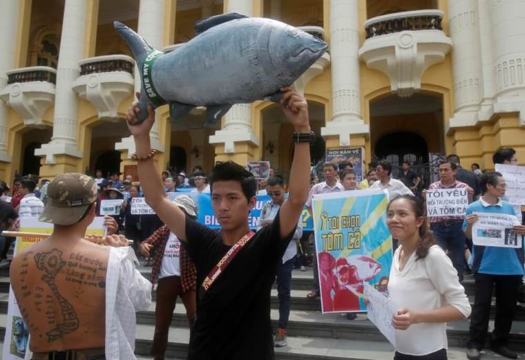 Demonstrators, holding signs of environmental-friendly messages, say they are demanding cleaner waters in the central regions after mass fish deaths in recent weeks, in Hanoi, Vietnam, May 1, 2016.